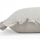 Side close-up of the Siena 14x20 ruffle lumbar pillow from Tonic Living, showcasing the soft edge ruffle and subtle beige stripes in a natural, earthy tone.