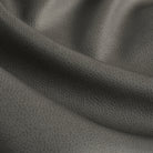 Close up of Tonic Living Smythe Charcoal faux leather upholstery fabric showing its deep charcoal colour and realistic leather grain.