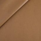 Tonic Living Smythe Faux Leather Fabric in Saddle, a brown performance upholstery fabric with the rich character of genuine leather.