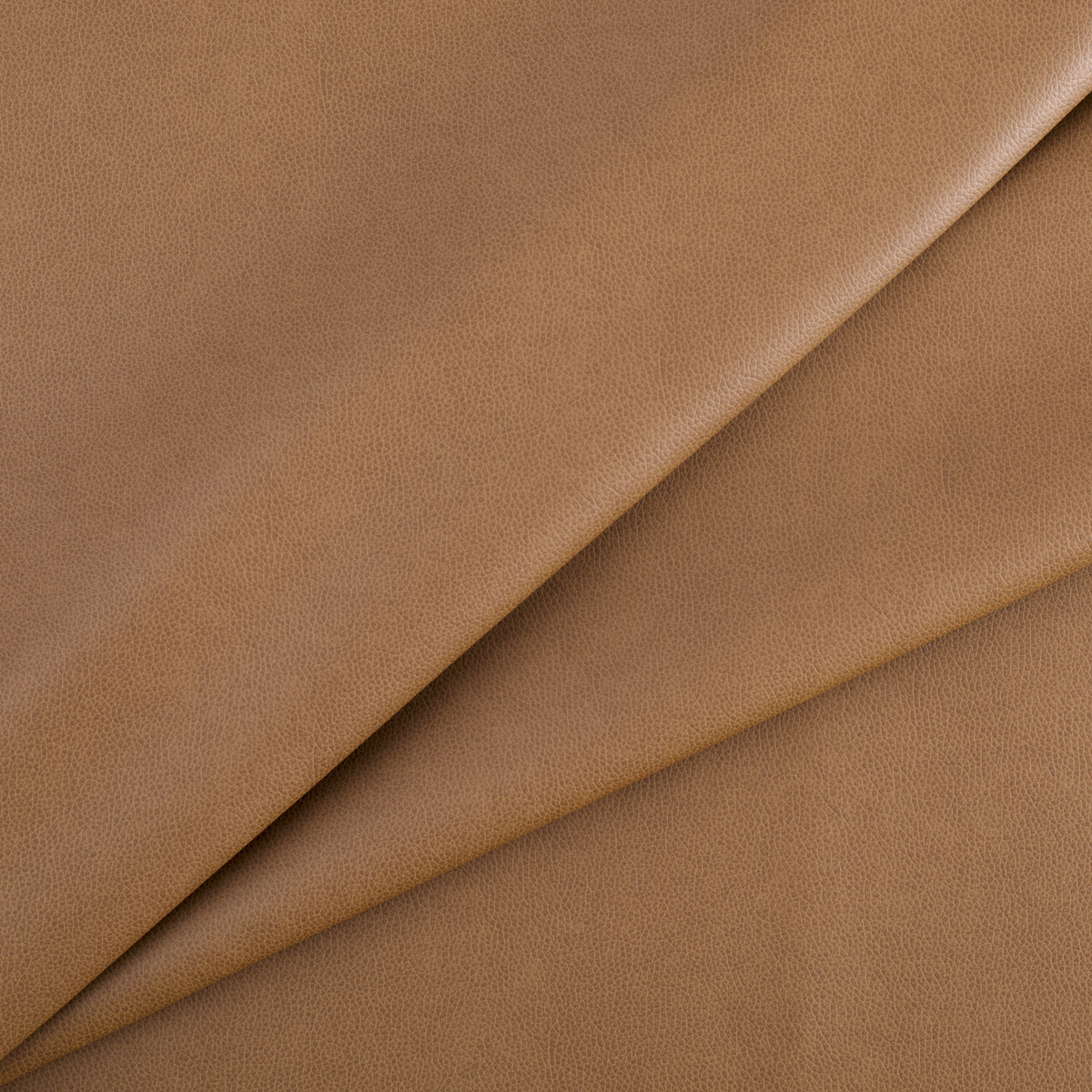 Tonic Living Smythe Faux Leather Fabric in Saddle, a saddle brown high-performance upholstery fabric with a natural leather look.