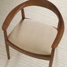 Tonic Living Smythe Sandstone faux leather upholstery fabric shown on a dining chair seat in a warm sandy beige.