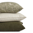 Stack of Tonic Living pillows including Cyprus Moss, Somerset Stripe Oatmeal, and Bedford Moss in green and neutral tones.