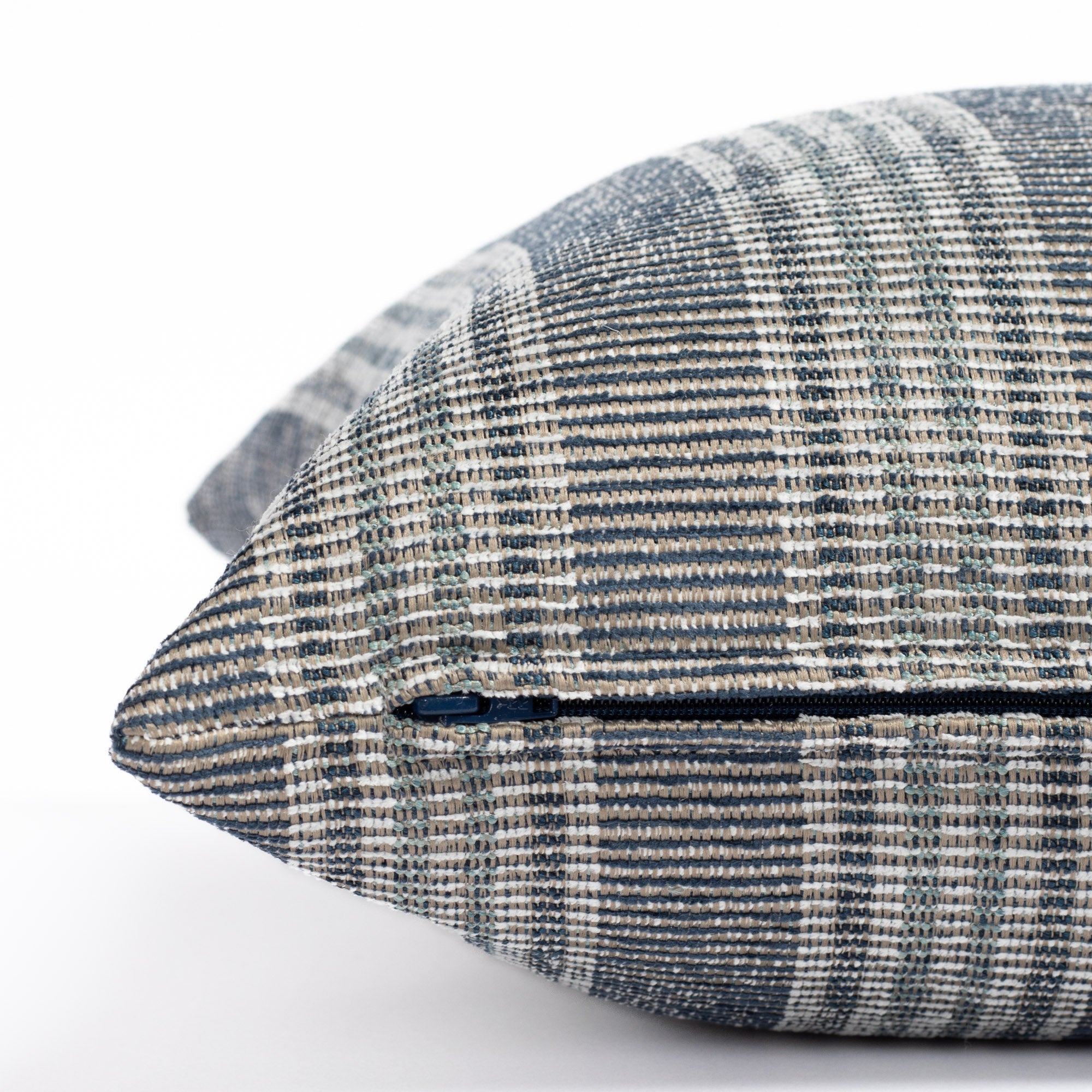 an indigo blue, aqua and white stripe outdoor pillow : close up zipper view