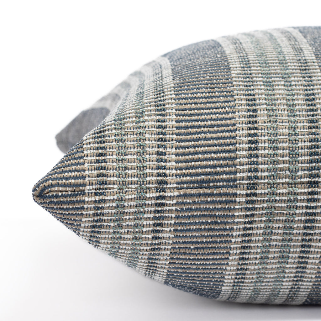 an indigo blue, aqua and white stripe outdoor pillow : close up side view