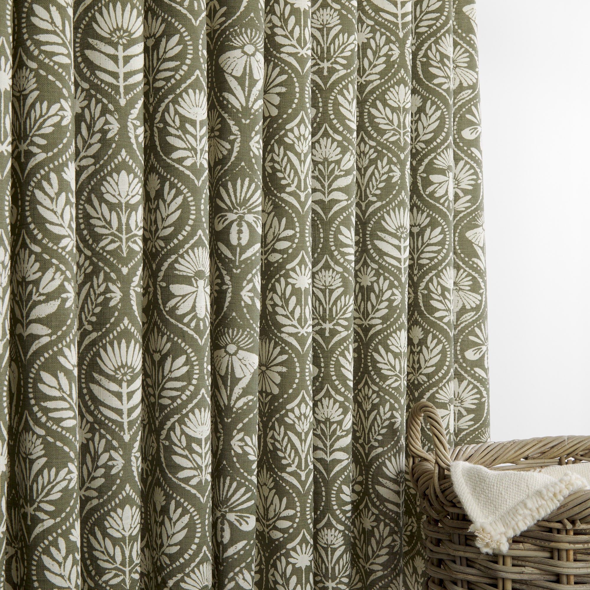 Tonic Living Stella Evergreen curtain fabric shown as drapery in olive green and natural block print design.