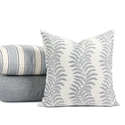 Tonic Living Swoon Denim throw pillow styled in front of a stack of blue toned outdoor pillows.