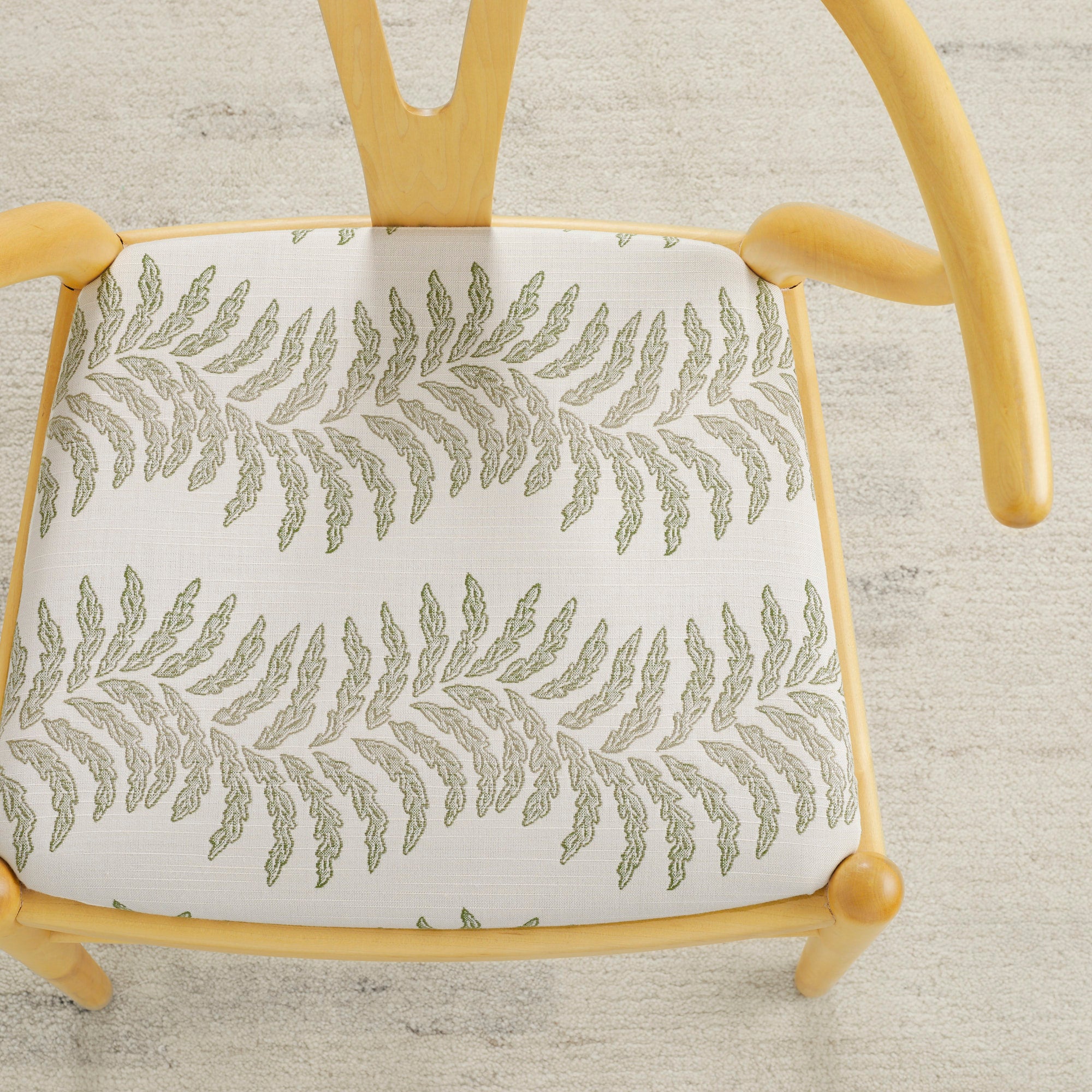 Tonic Living Swoon Sunbrella Sage indoor/outdoor upholstery fabric on a dining chair seat in green botanical stripe.