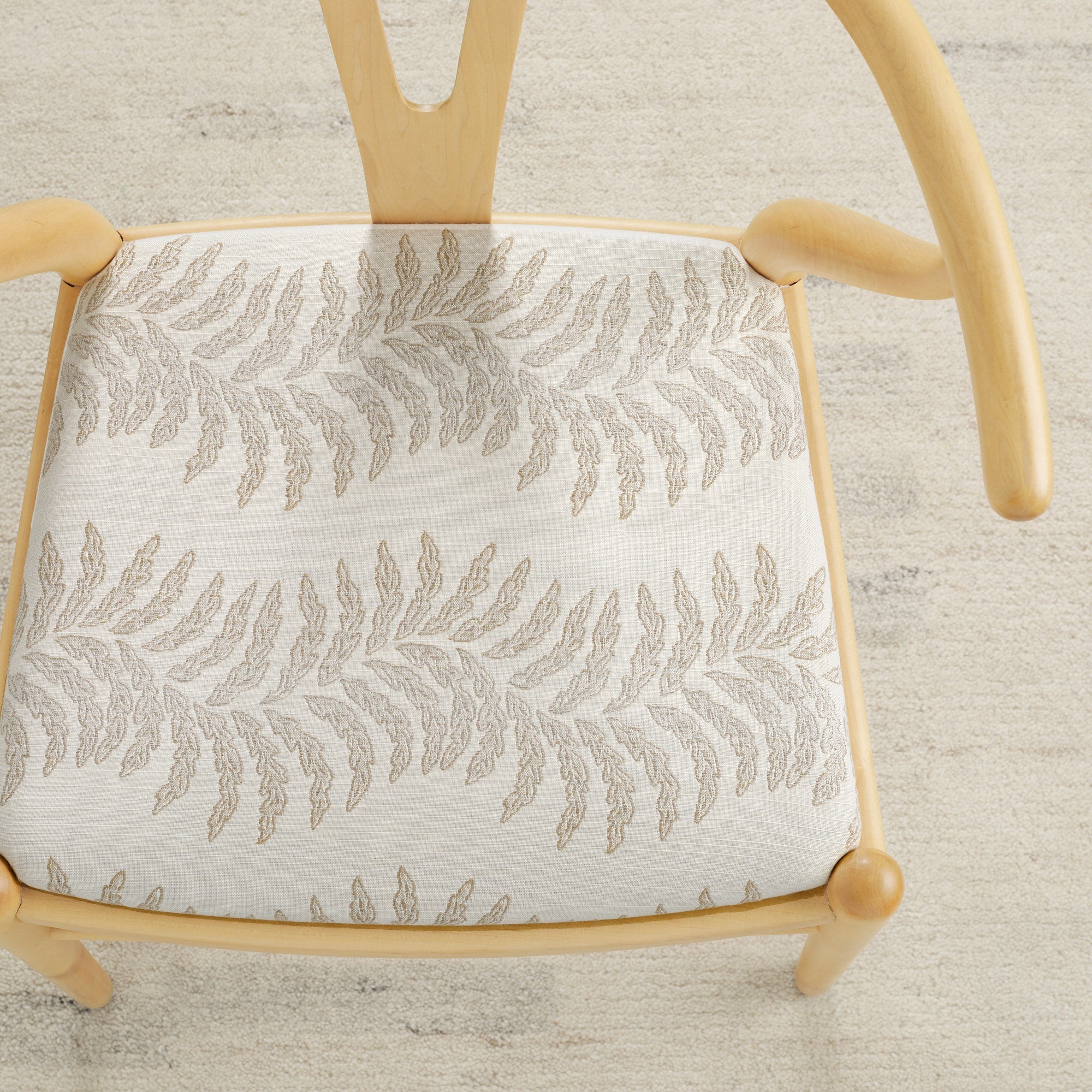 Tonic Living Swoon Sunbrella Sand indoor/outdoor upholstery fabric on a dining chair seat in neutral botanical stripe.