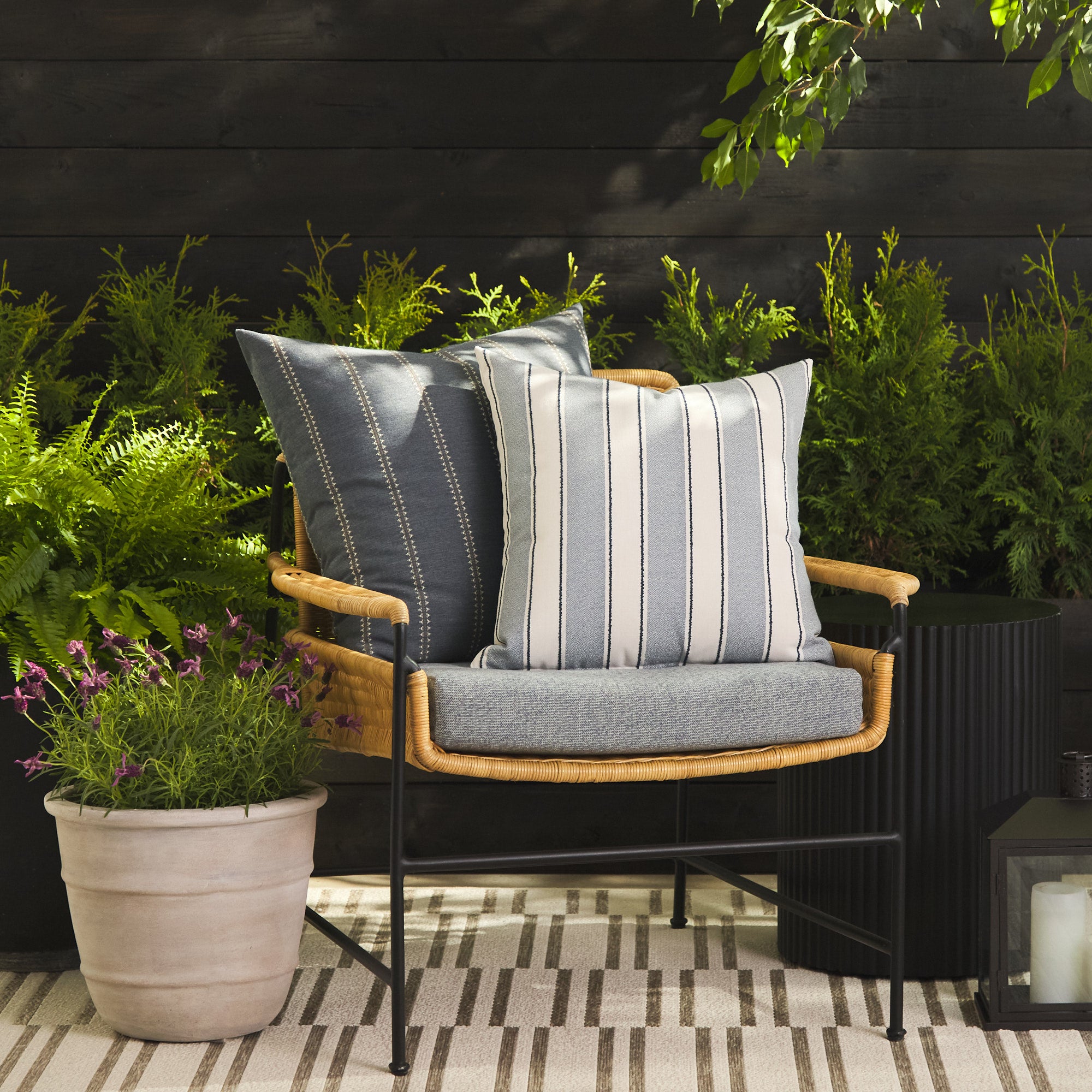 Tonic Living Sentiment Denim decorative cushion styled on a chair with Talisman Denim 22x22 pillow outdoors.