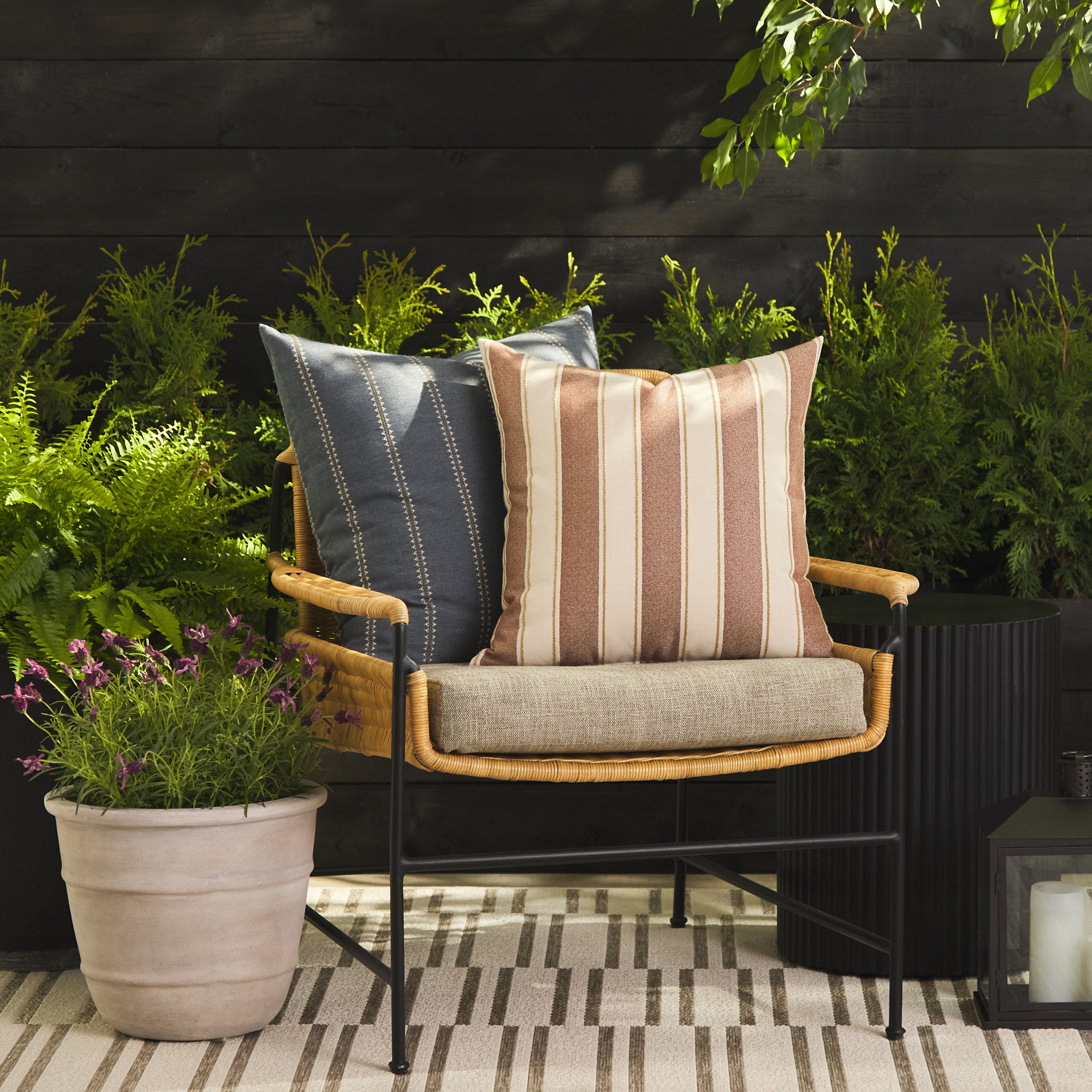 Tonic Living Sentiment Terracotta throw pillow styled on a chair with Talisman Denim 22x22 cushion outdoors.