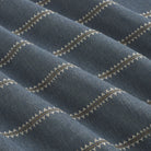 Tonic Living Talisman Sunbrella Denim blue indoor/outdoor upholstery fabric with a refined geometric stripe on a dark blue base.