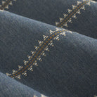 Close up of Tonic Living Talisman Sunbrella Denim blue fabric showing raised stitch detail in a multicolour geometric stripe.