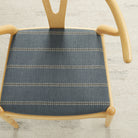 Tonic Living Talisman Sunbrella Denim blue indoor/outdoor upholstery fabric on a dining chair seat with a textured geometric stripe.