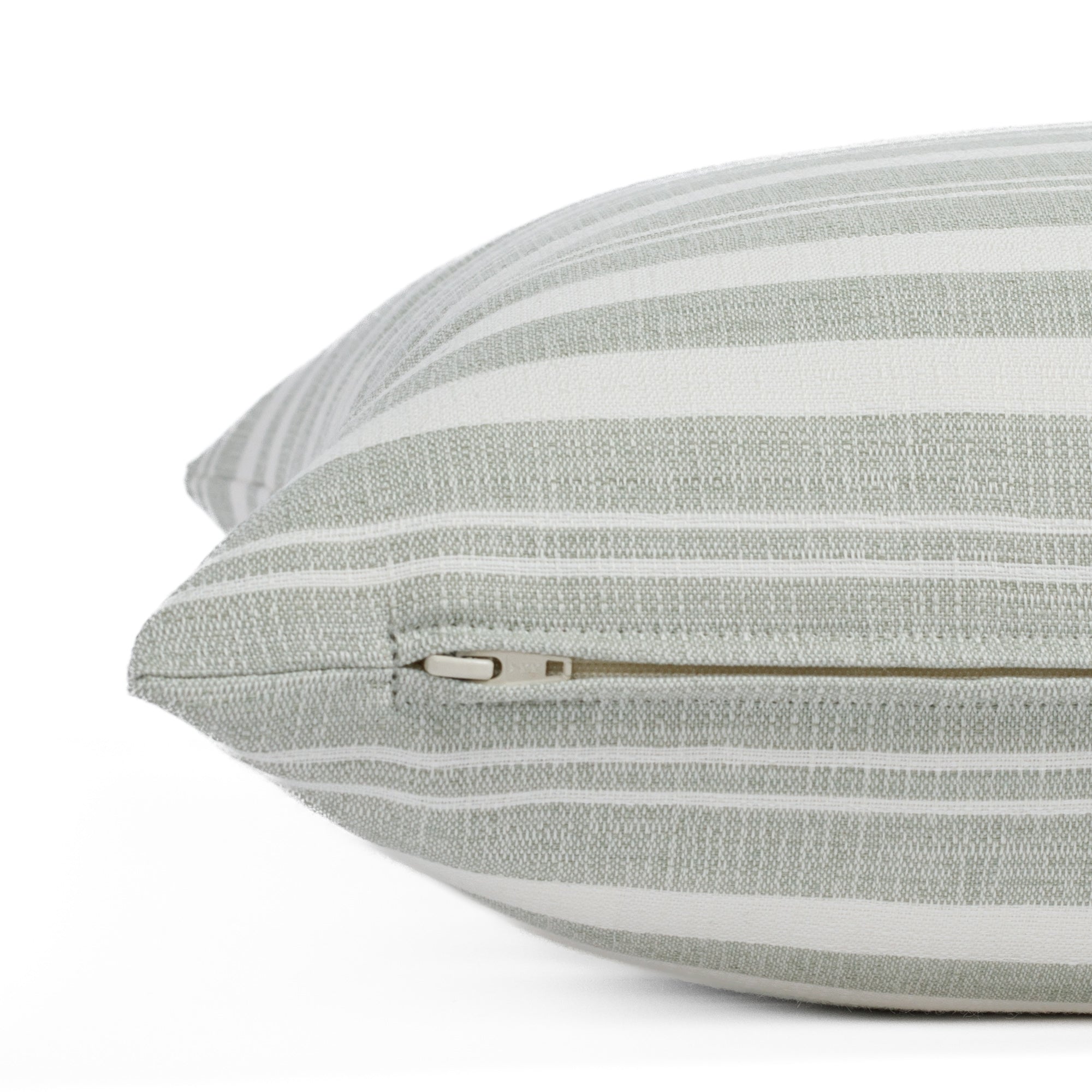A light green and white striped throw pillow from Tonic Living: close-up zipper view.