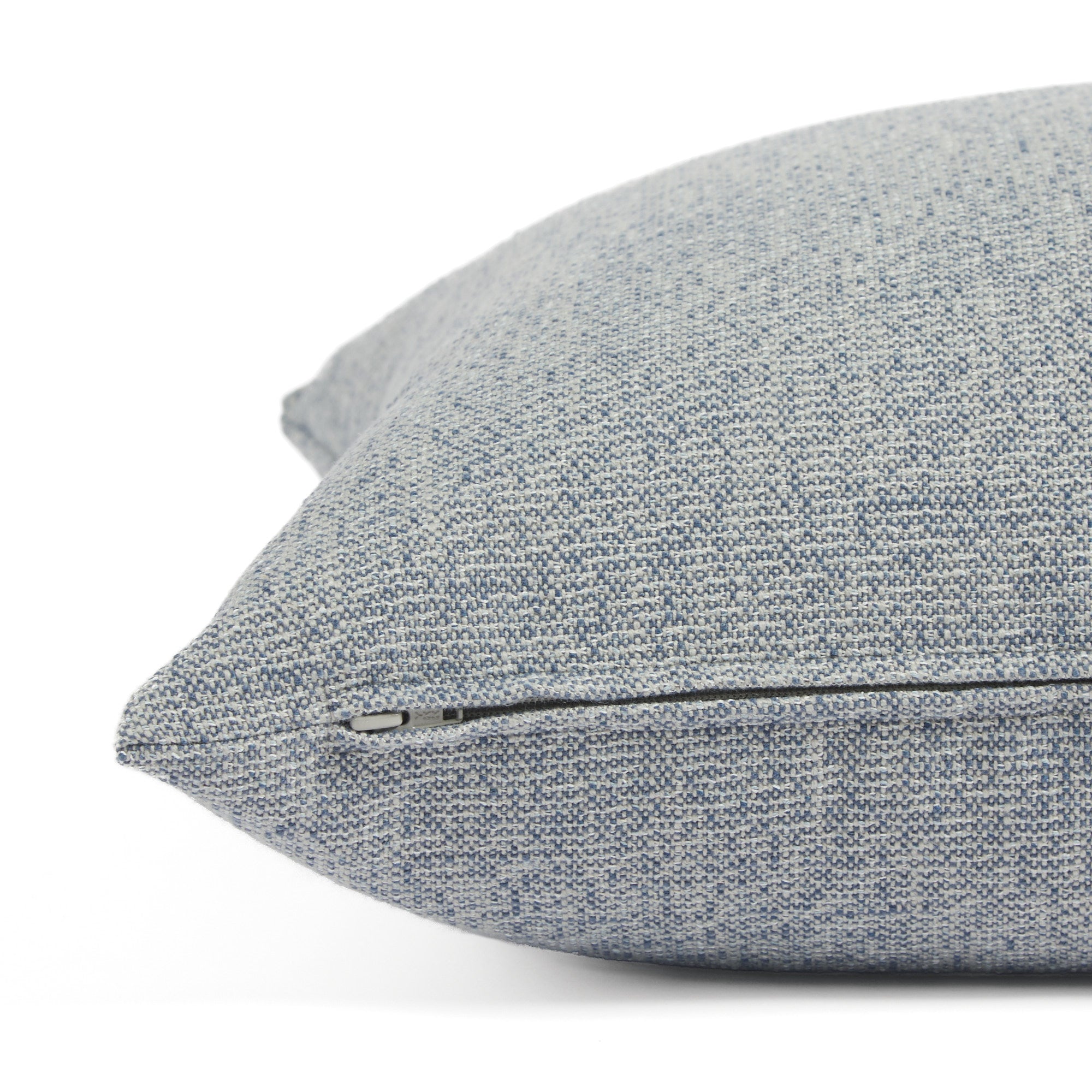 Side zipper detail of Tonic Living Troy 22x22 outdoor toss pillow in solid blue textured fabric.