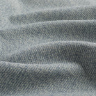 Close up of Tonic Living Troy InsideOut Denim upholstery fabric highlighting its solid blue textured, linen-inspired weave.