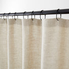 Tonic Living Tuscany Linen Shower Curtain in Oatmeal Slub, an oatmeal greige linen shower curtain hanging from black curtain rings.