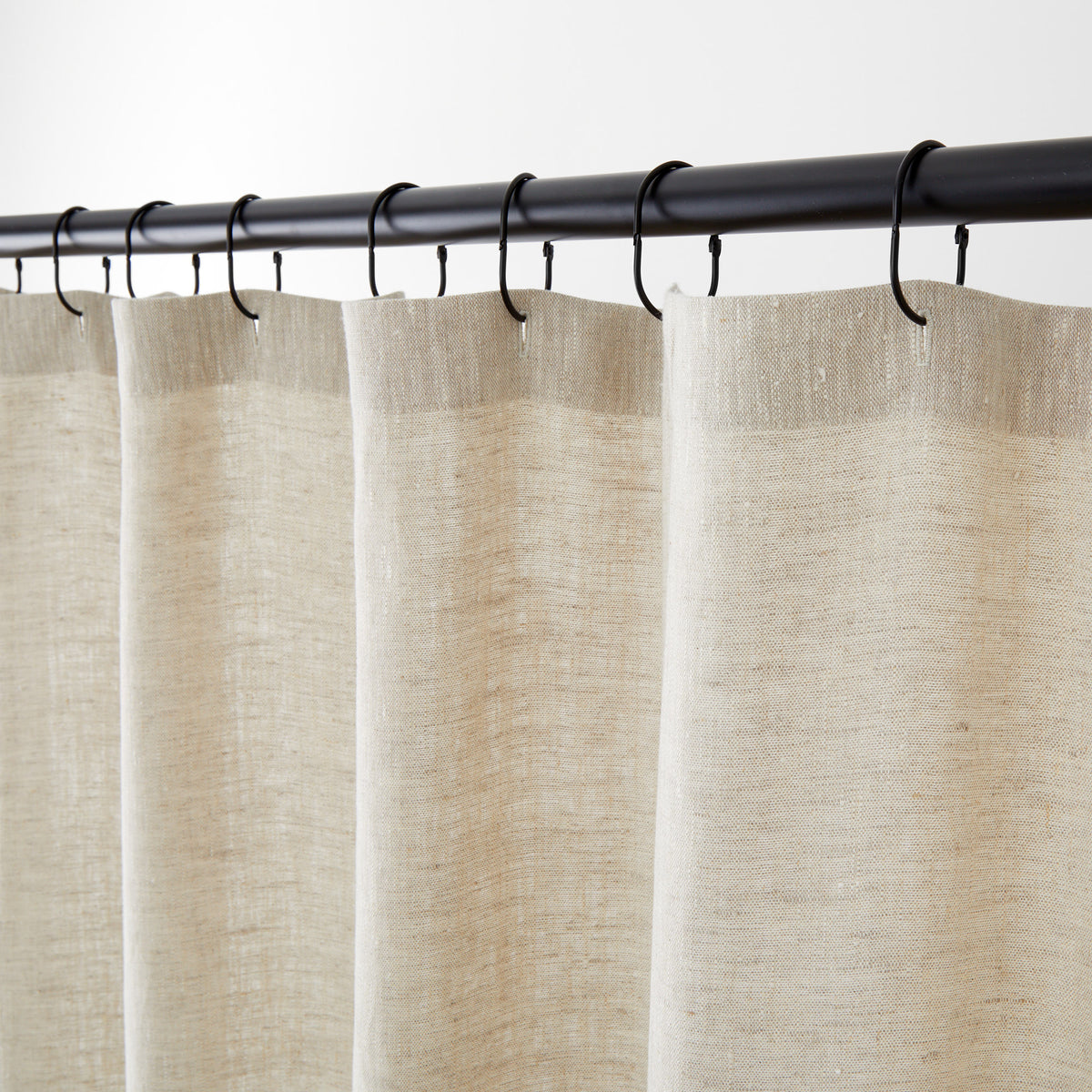 Tonic Living Tuscany Linen Shower Curtain in Oatmeal Slub, an oatmeal greige linen shower curtain hanging from black curtain rings.