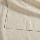 Close up of Tonic Living Tuscany Linen Shower Curtain in Oatmeal Slub showing its wide hem and oatmeal greige linen texture.