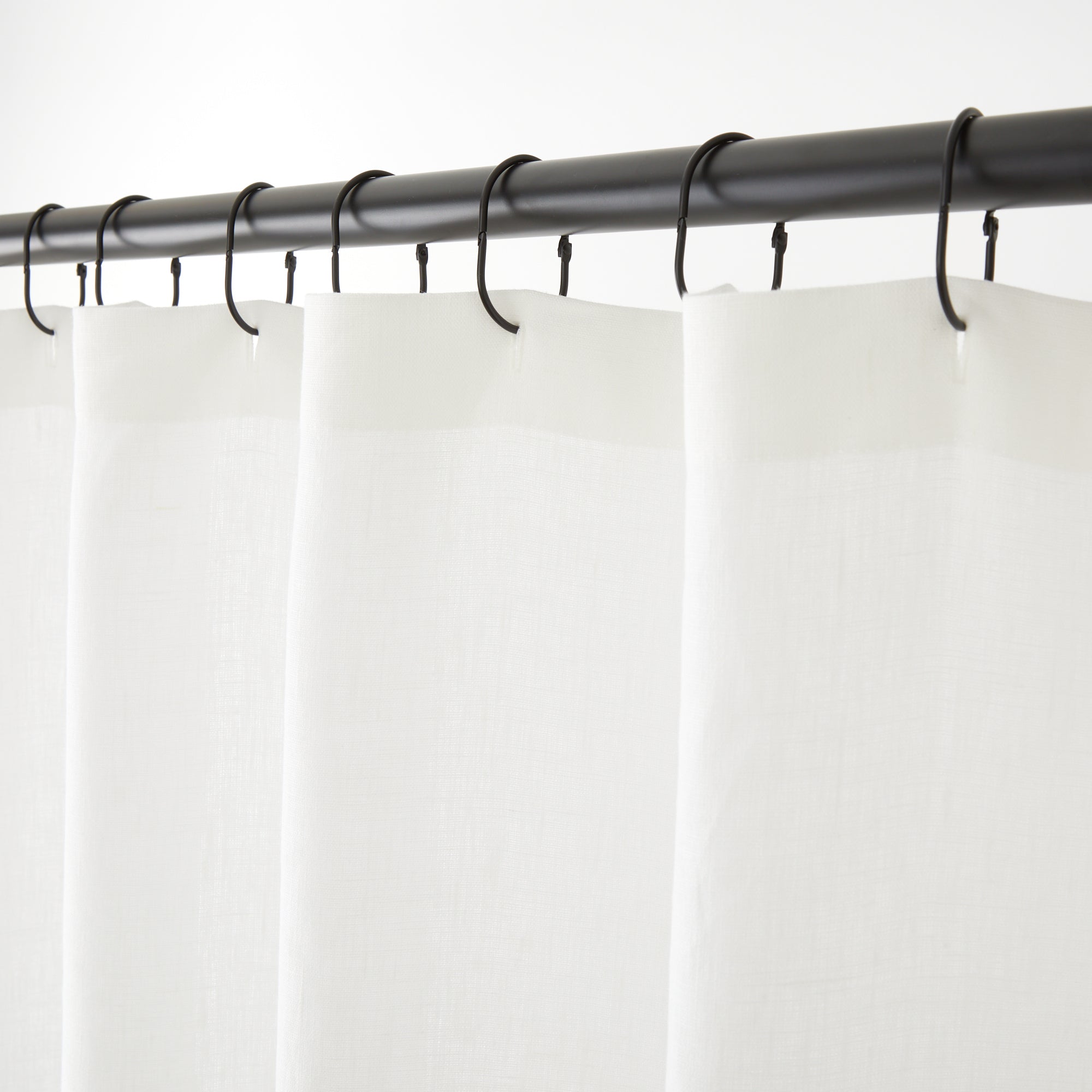Tonic Living Tuscany Linen Shower Curtain in Oyster, a warm white linen shower curtain hanging from black curtain rings.