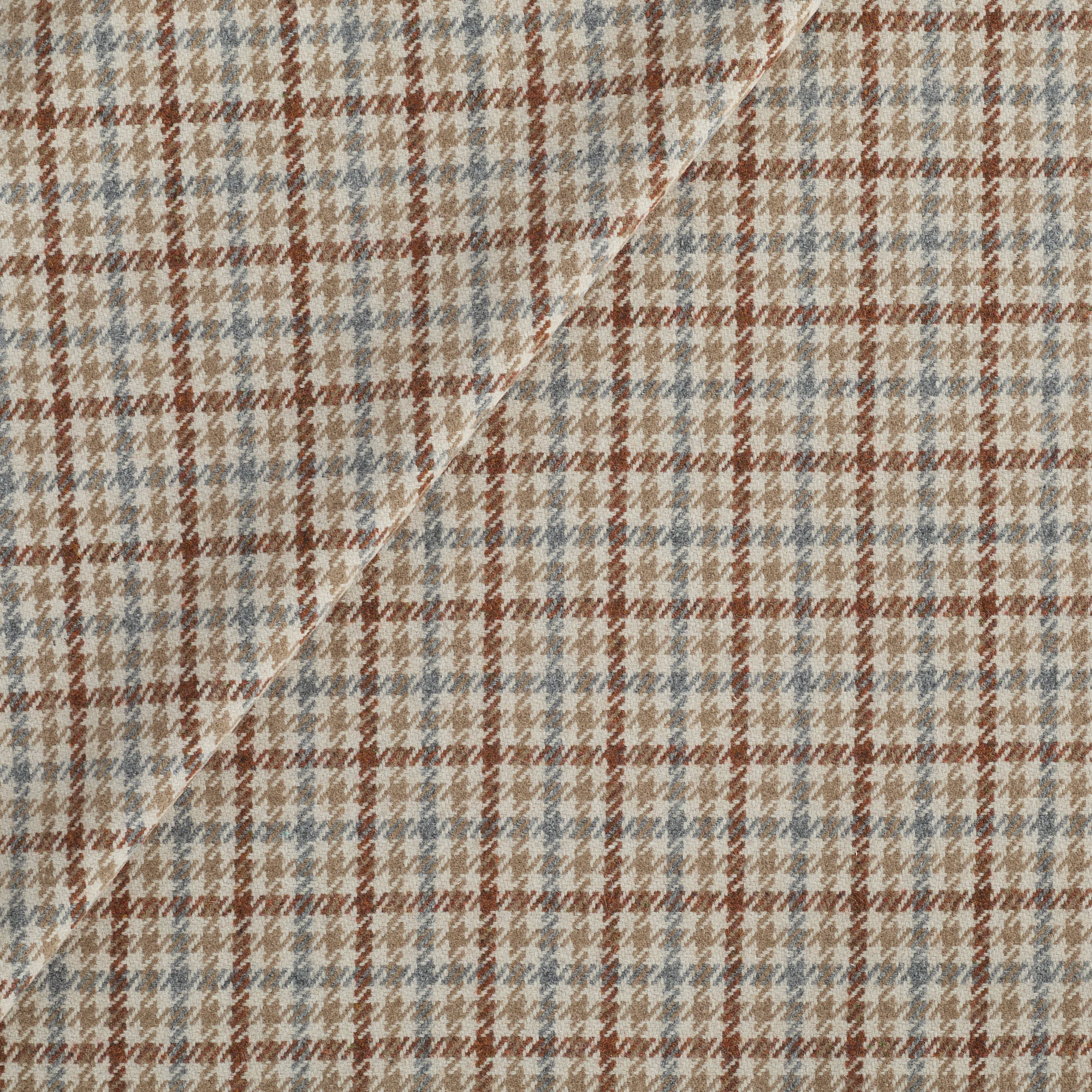 Vesper Paprika houndstooth upholstery fabric in beige, blue, and rust by Tonic Living.