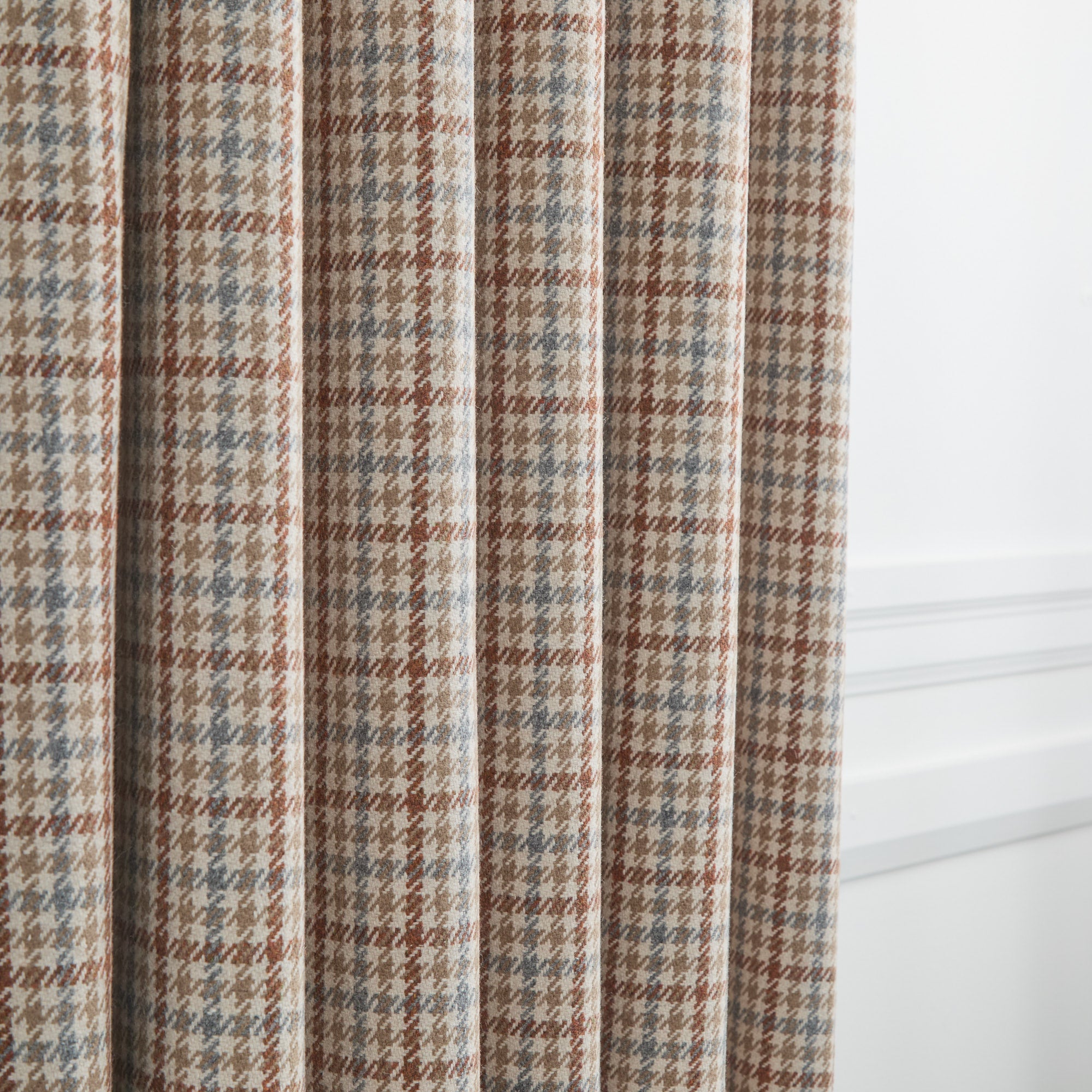 Vesper Paprika plaid home decor fabric shown as curtains in beige, blue, and rust.