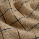 Close up of Tonic Living Walker Plaid Camel fabric showing a fine herringbone weave and windowpane check in camel, brown, and navy.