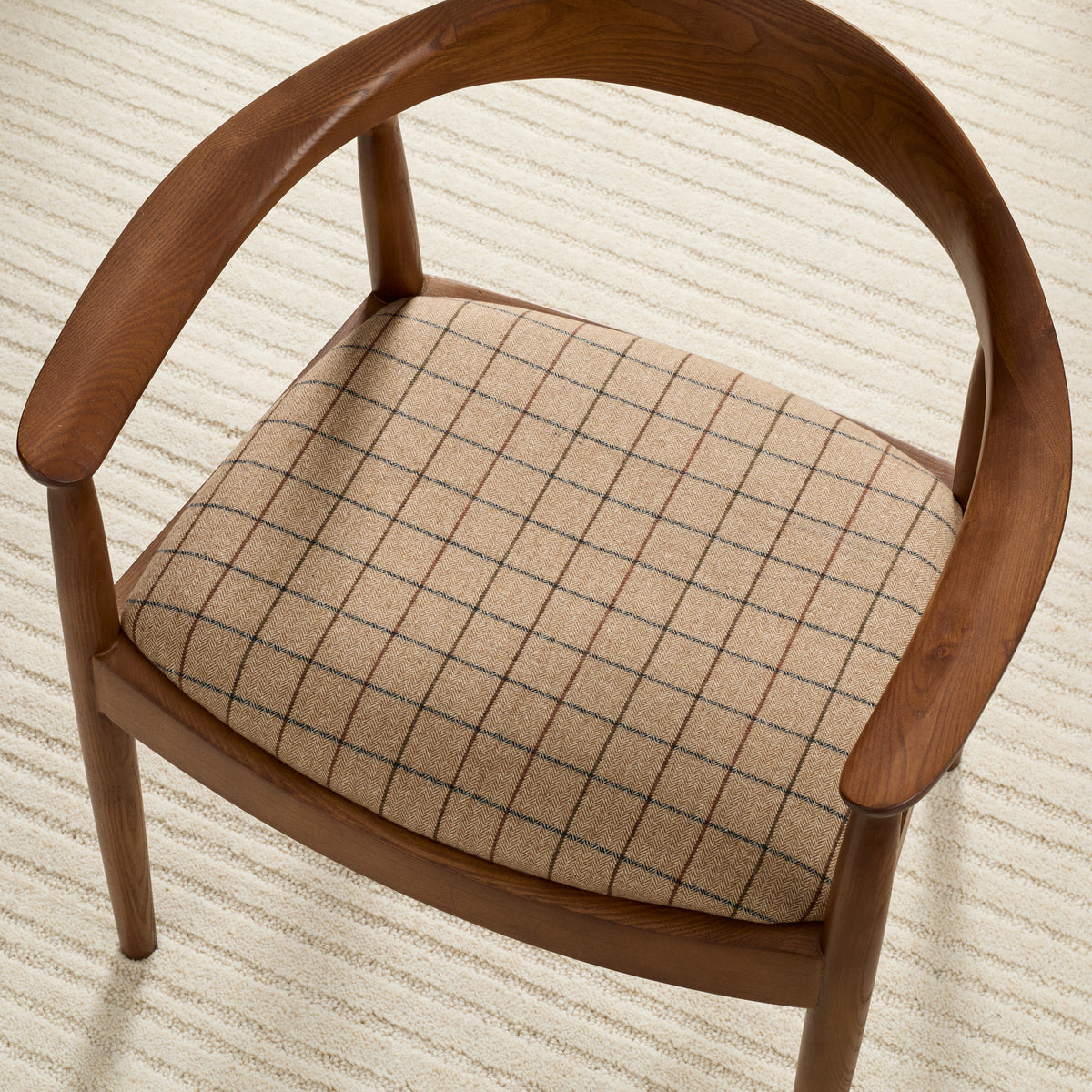 Tonic Living Walker Plaid Camel upholstery fabric shown on a chair seat with a tailored windowpane check pattern.