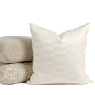 Tonic Living Webster Buff decorative pillow styled in front of a stack of neutral throw pillows.