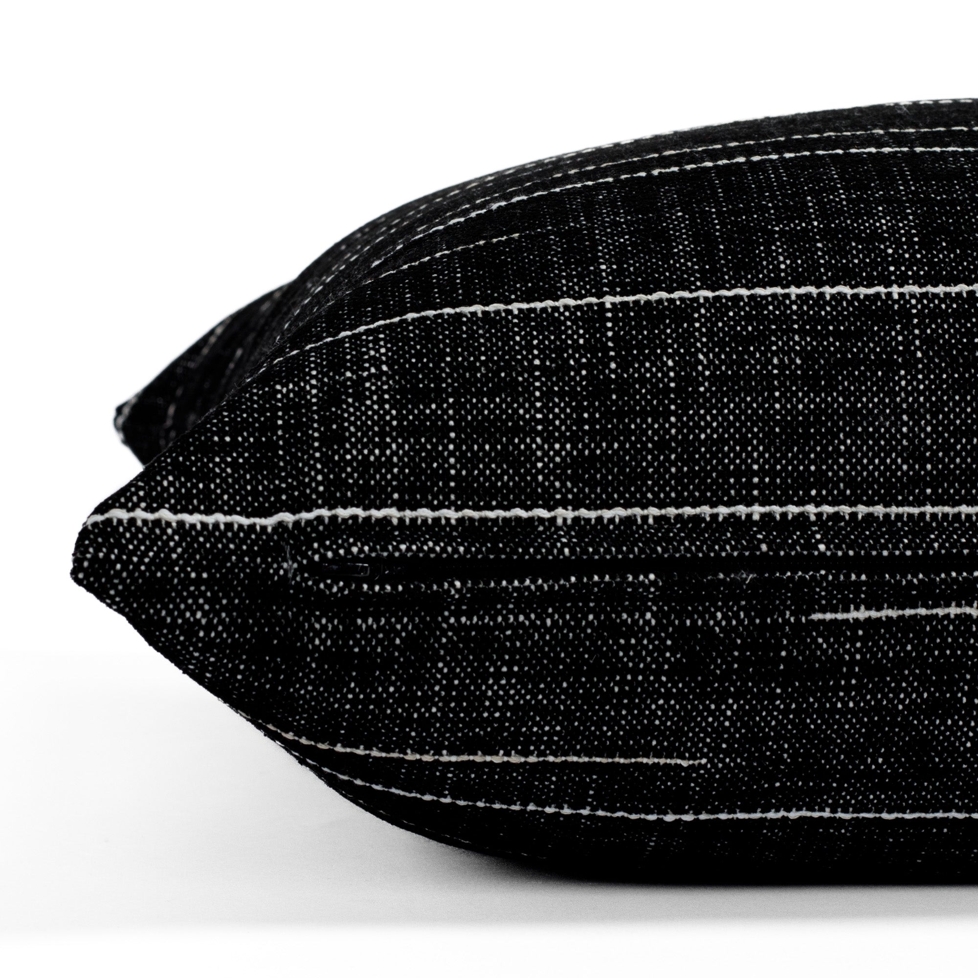 Yuzu Onyx, a black and white pillow from Tonic Living, showcasing a dappled texture accented with organic white lines: close-up zipper view.