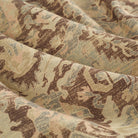 Close up of Tonic Living Zuri Driftwood fabric showing a faded medallion pattern in brown, beige, dusty blue, and blush pink.