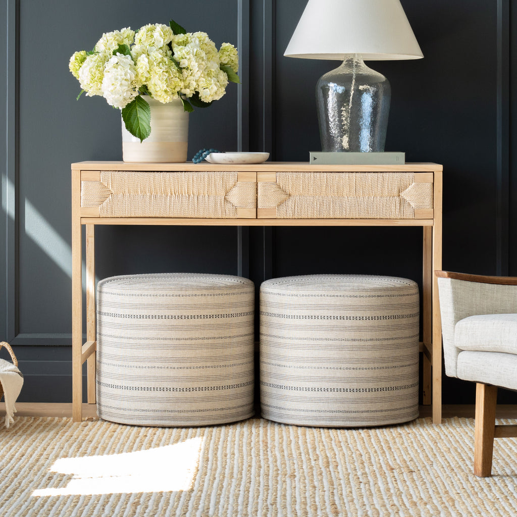 two beige and charcoal stripe round ottomans under a console
