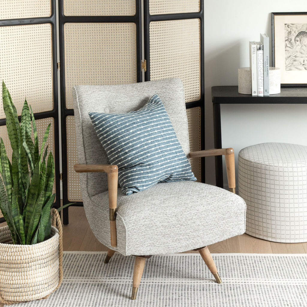 Home decor vignette from Tonic Living : Arren Stripe chambray blue pillow, Natura Linen upholstered chair and Keely Check Birch round ottoman