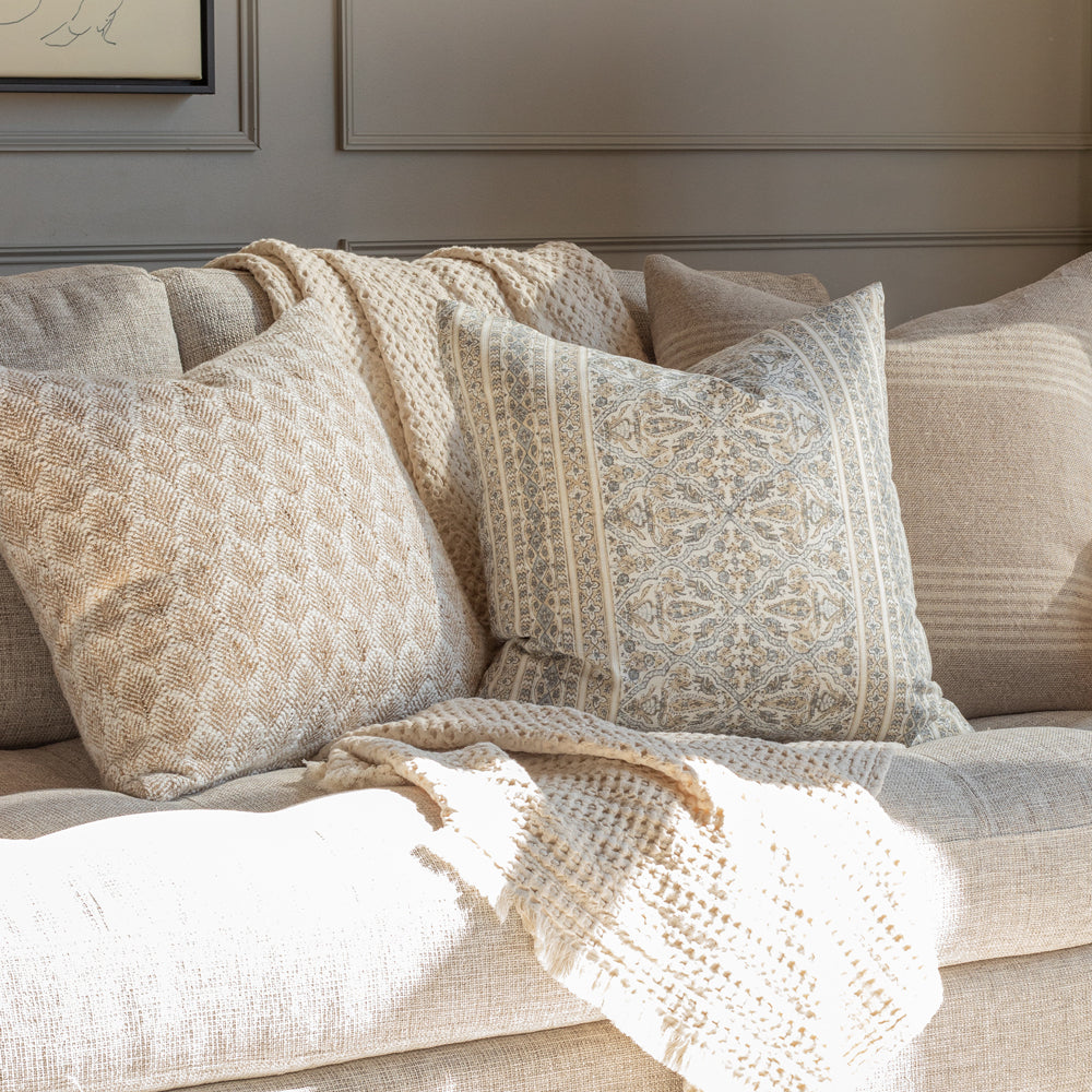 Cozy neutral throw pillows with floral and stripe patterns in tan, beige and grey from Tonic Living