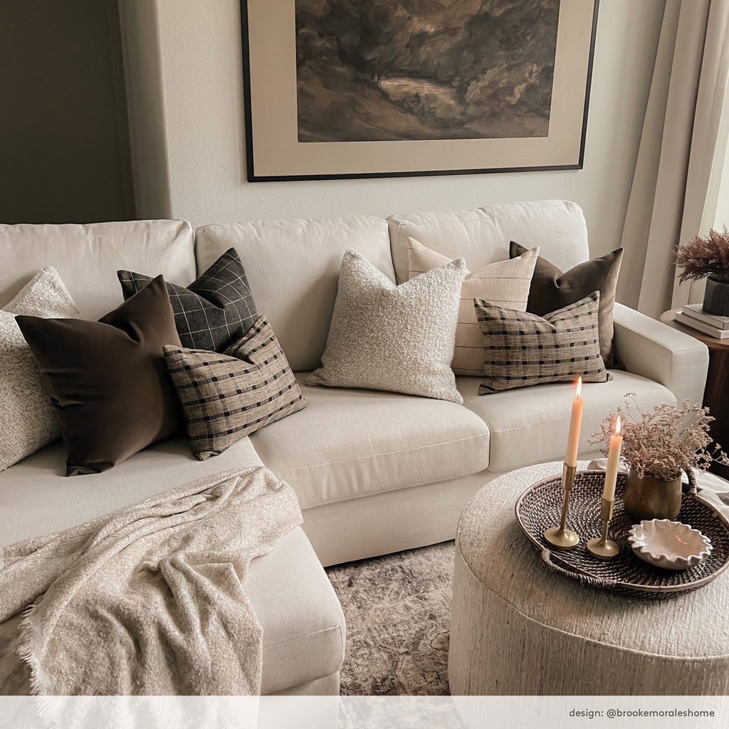 Brown, natural, textured and patterned pillows on a sectional sofa in a neutral living room. Home of Brooke Morales.