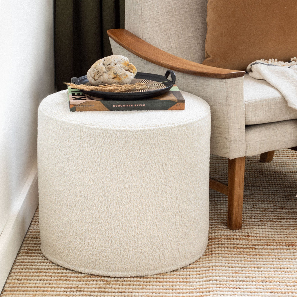 Cambie Boucle Chalk Round Ottoman with a book, used as a side table