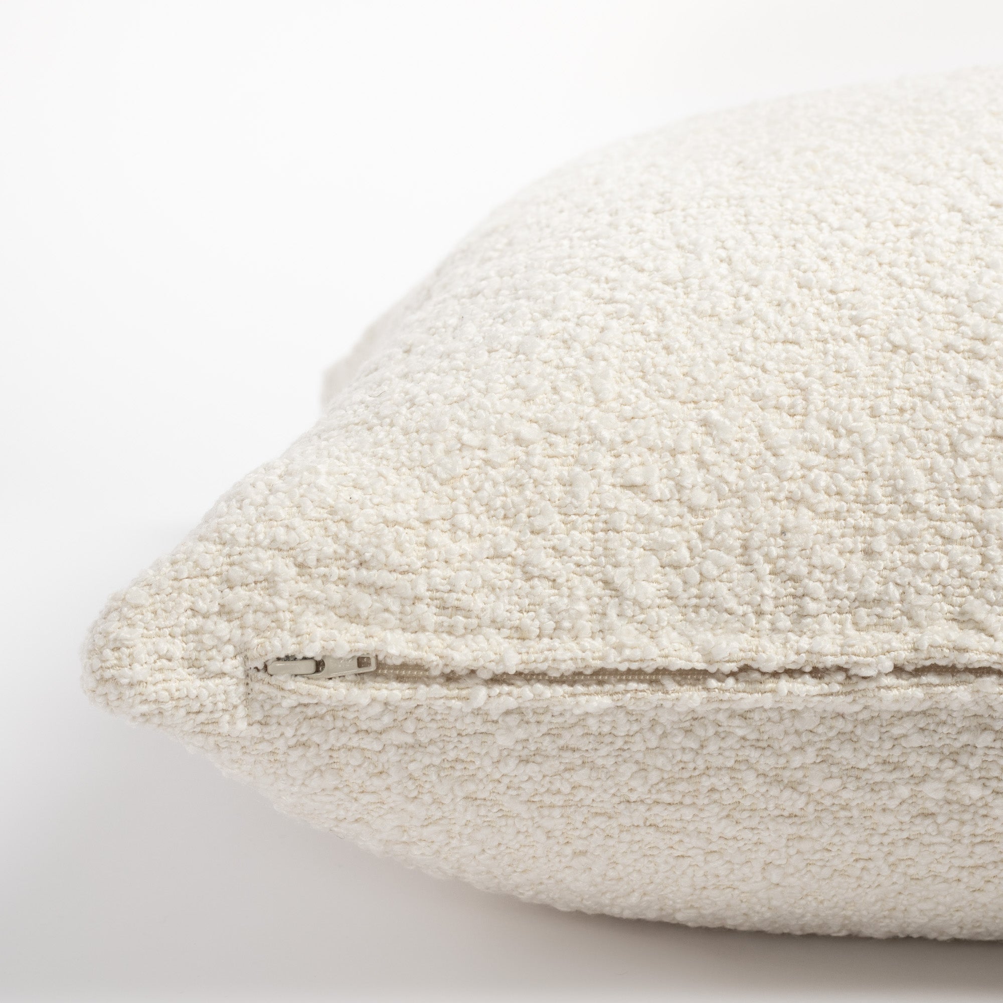 Cambie Boucle Chalk pillow, a cream boucle pillow with a beautiful chunky weave : close up zipper side