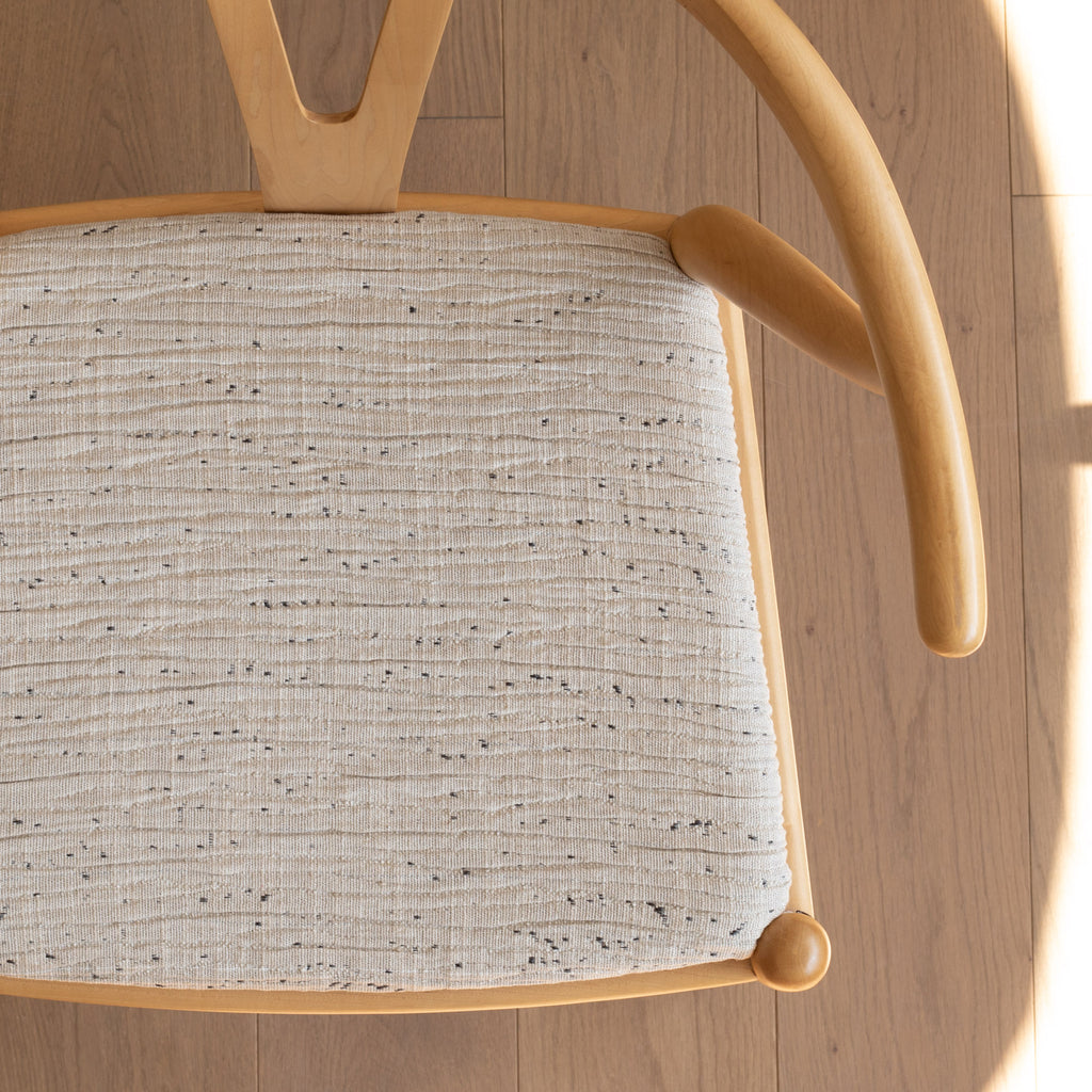 a textured beige upholstered fabric chair seat