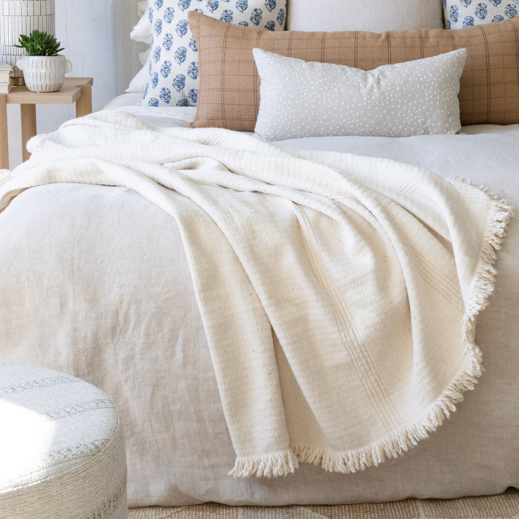 Cozy Bedscape: pillows and cream throw blanket from Tonic Living