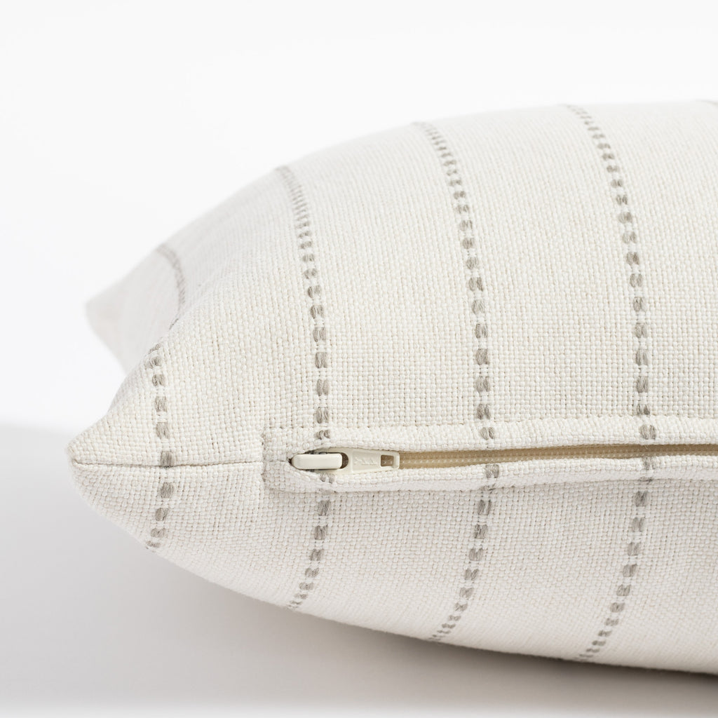 a cream and grey vertical striped pillow : zipper detail
