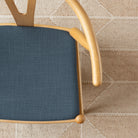 Grange Fabric Storm Blue, a high performance denim blue upholstery fabric shown on a chair seat