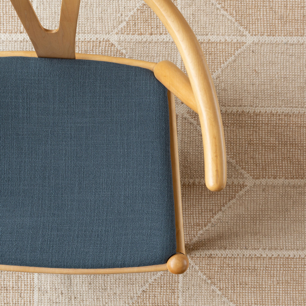 Grange Fabric Storm Blue, a high performance denim blue upholstery fabric shown on a chair seat