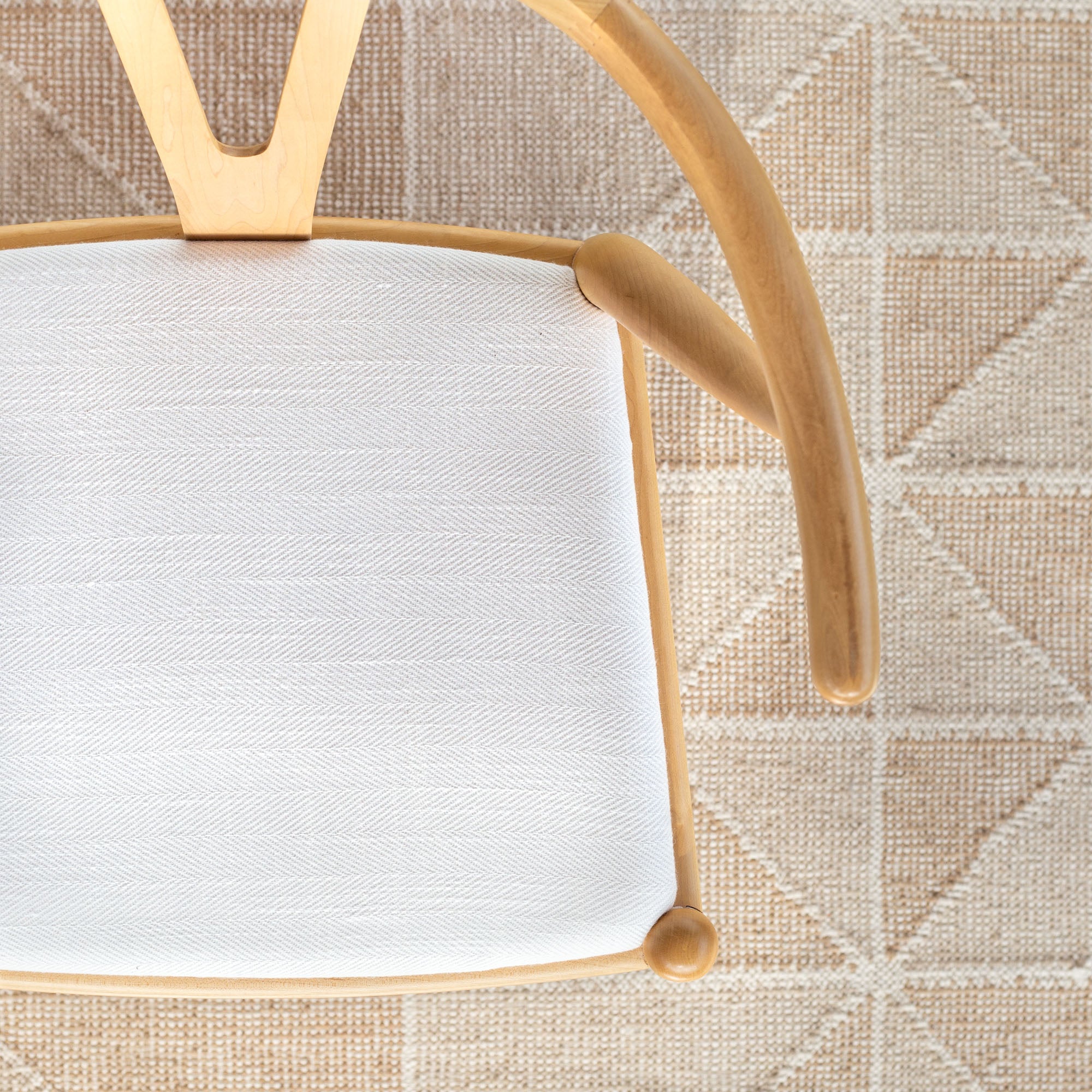 Upholstered dining chair seat cushion. White high performance upholstery fabric with a herringbone pattern and texture.