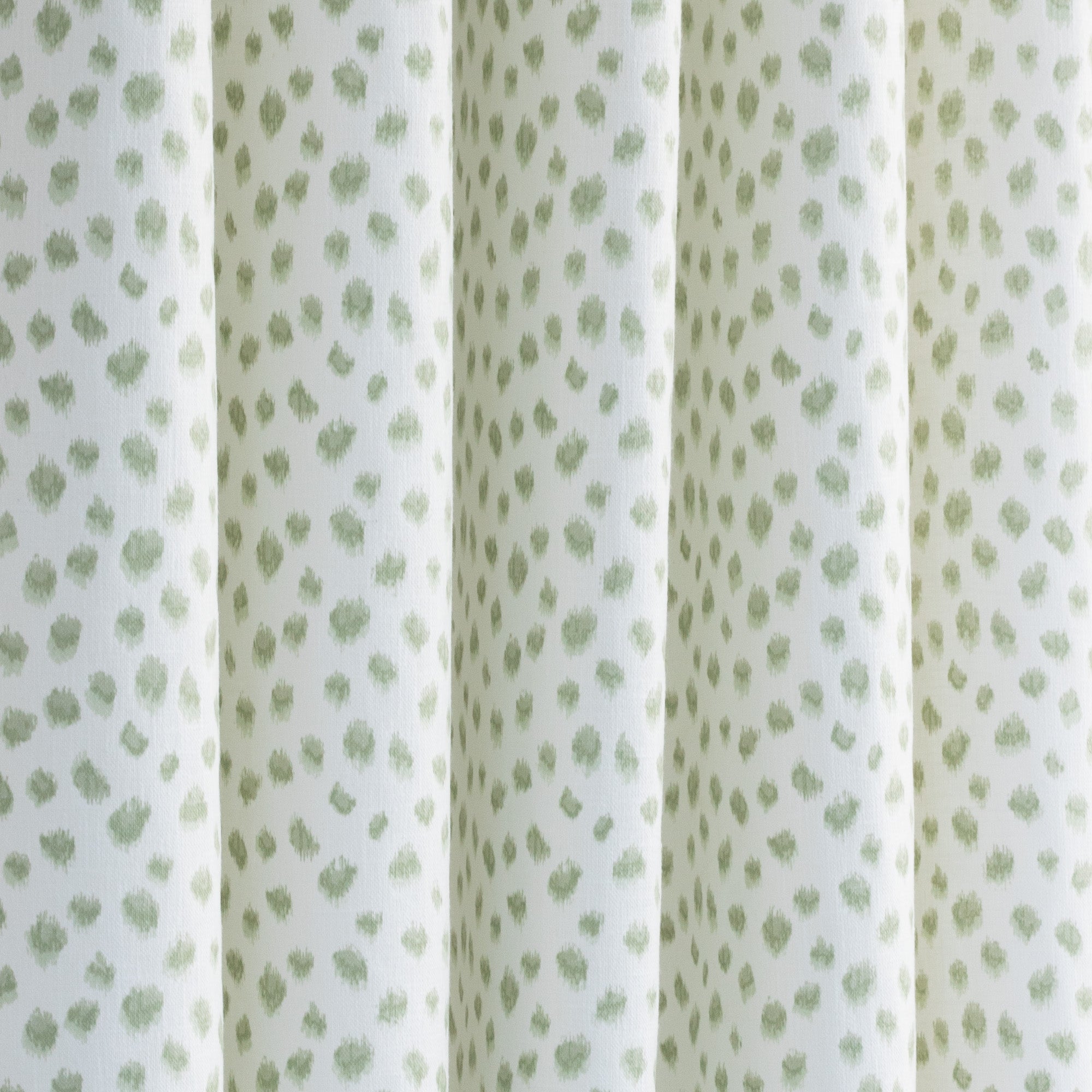 a white and green inky polka dot print curtain fabric