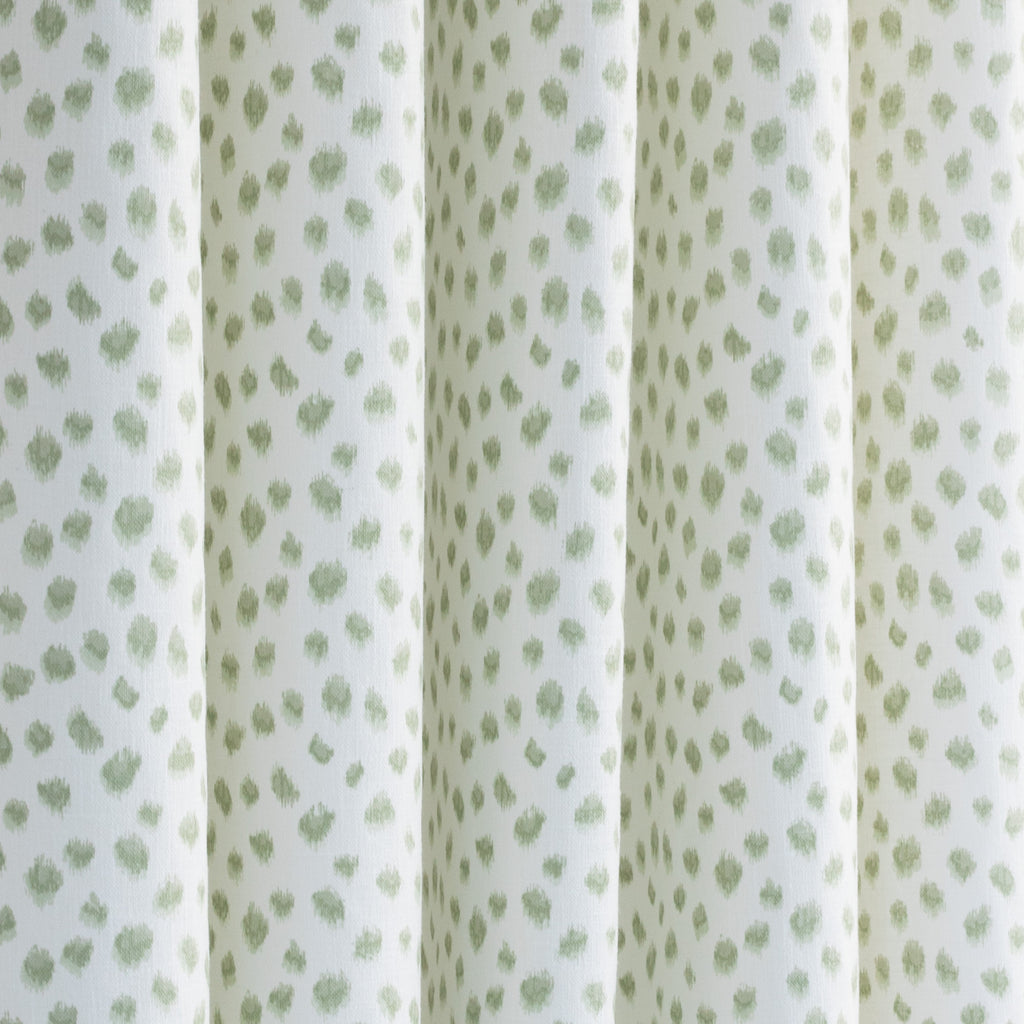 a white and green inky polka dot print curtain fabric
