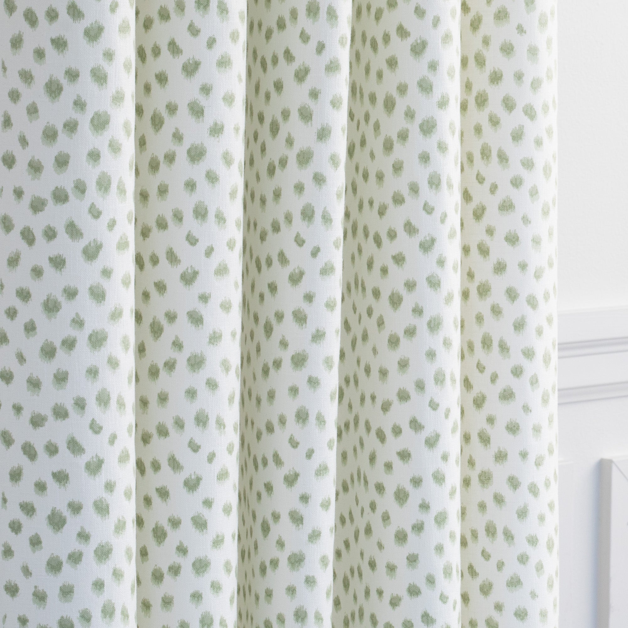 a white and green inky dot print drapery fabric