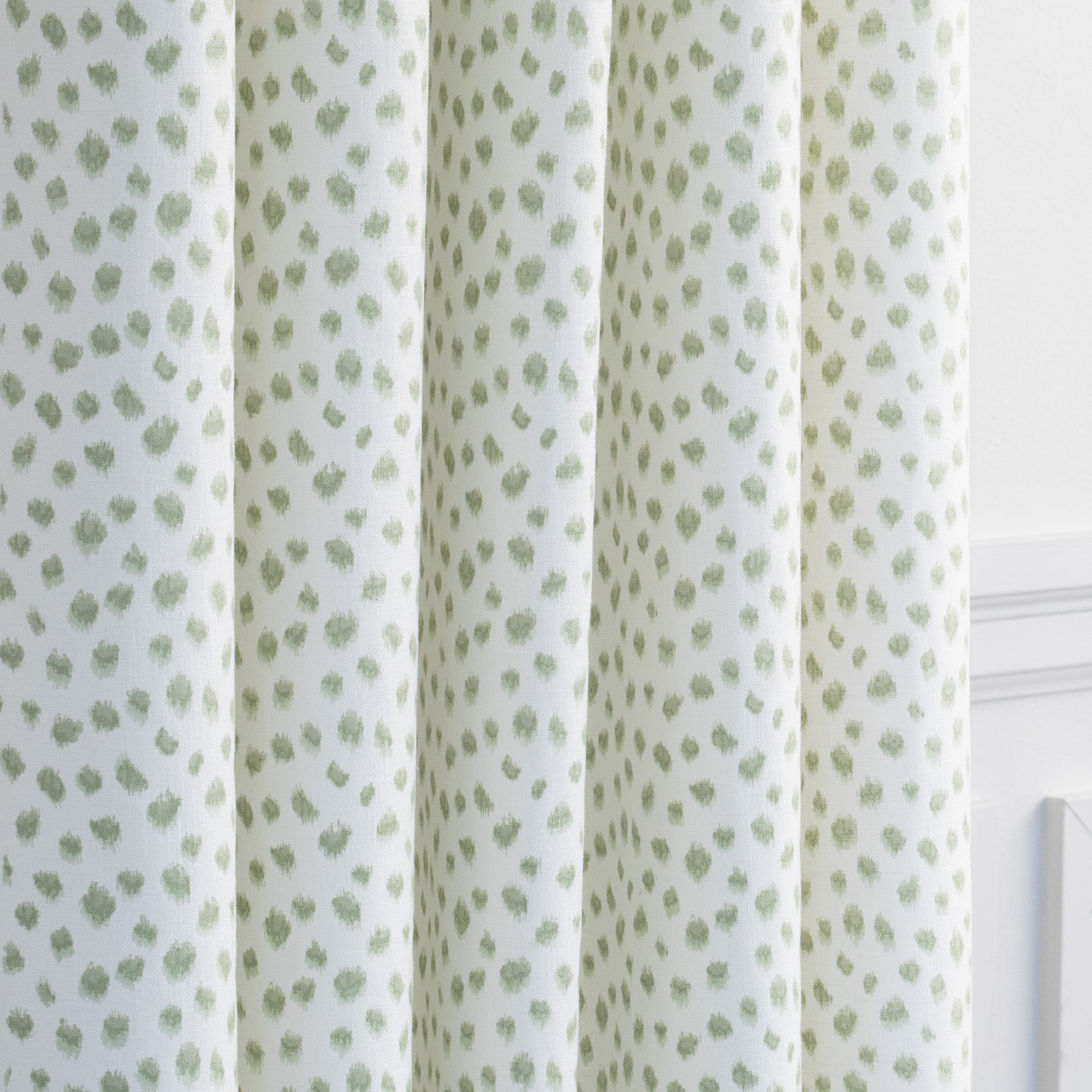 a white and green inky dot print drapery fabric