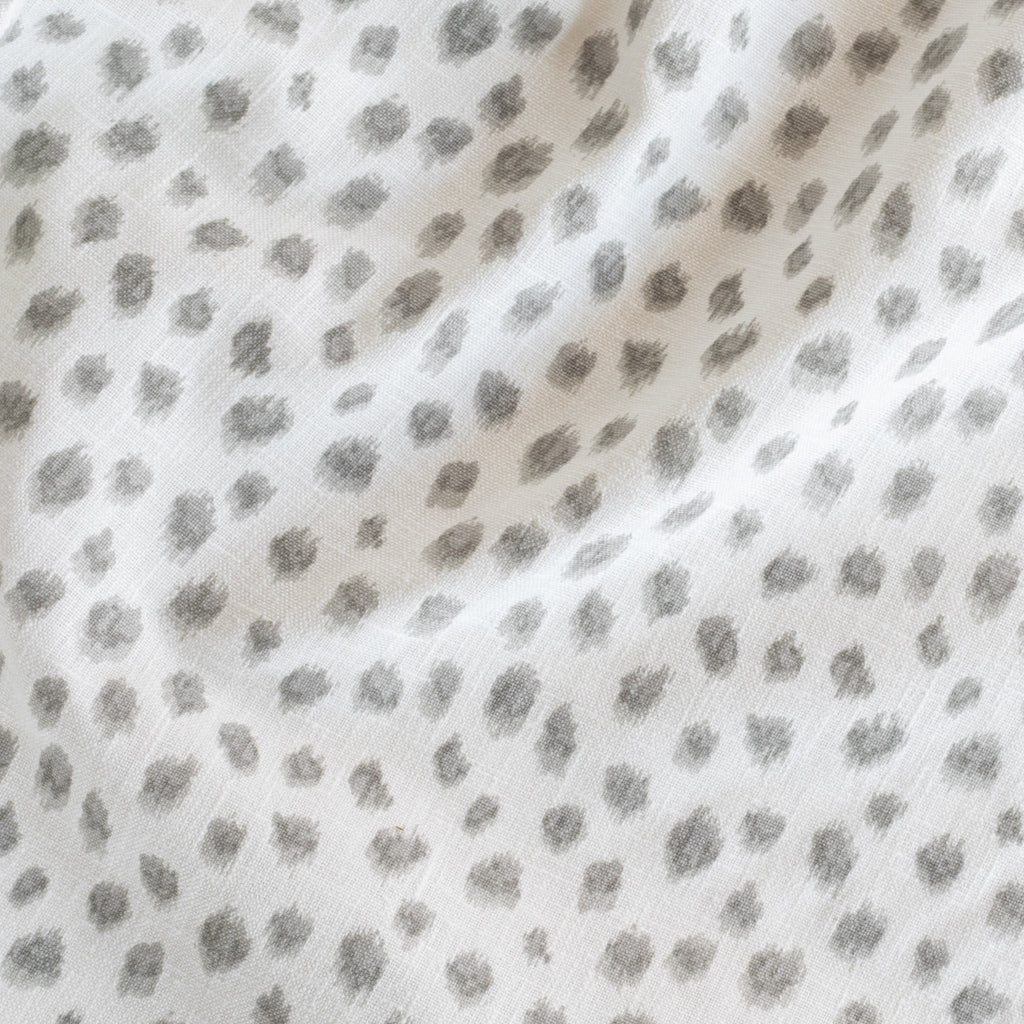 a white and silver grey inky polka dot print fabric