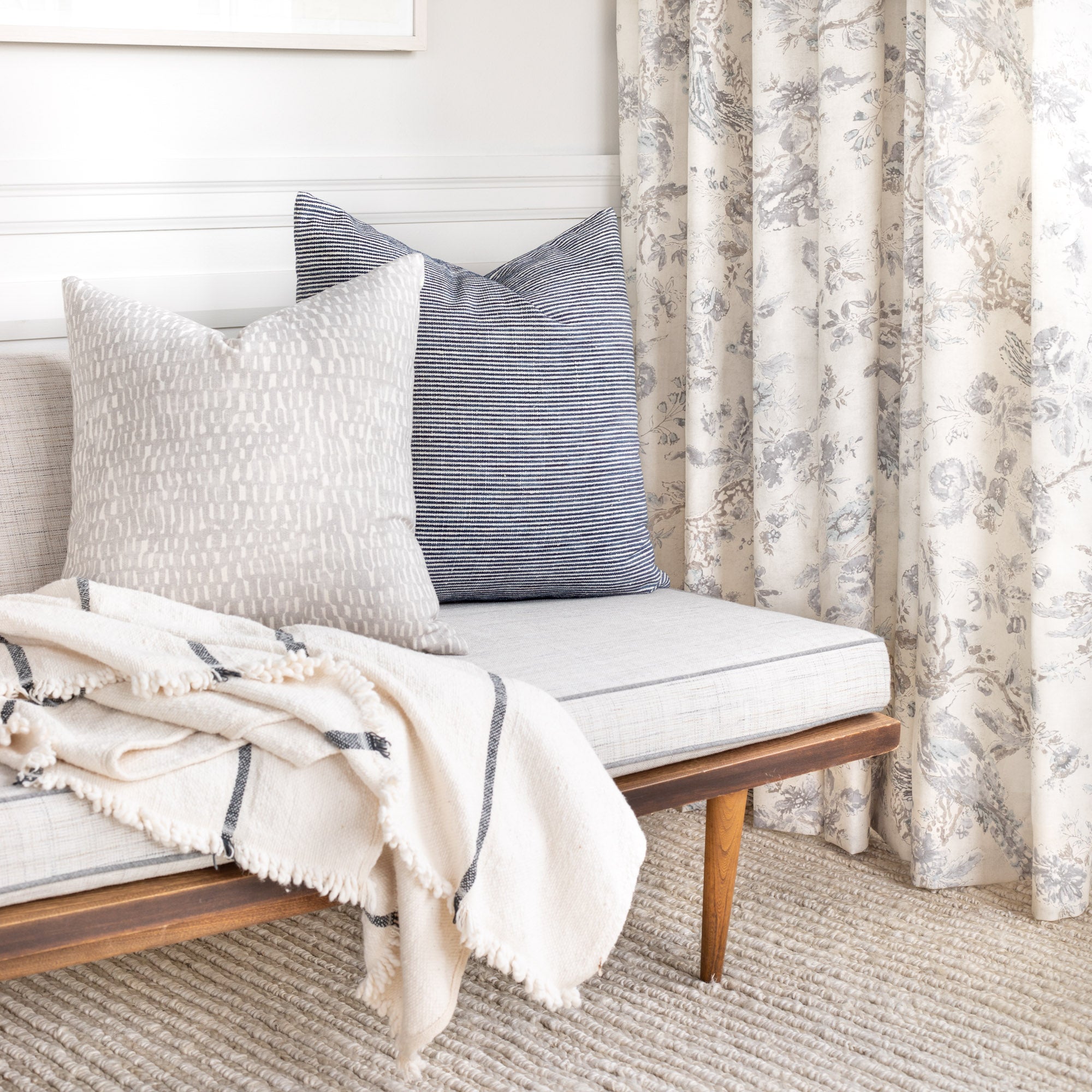 Grey and blue living room vignette: Marklin pillow and Avareno pillow on sofa with Collette Flint drapes