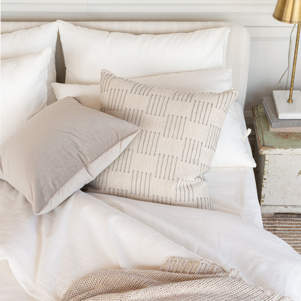 gray velvet and beige pattern pillow on a bed